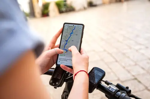 Person holding phone looking at a map of Sicily Biking Tour